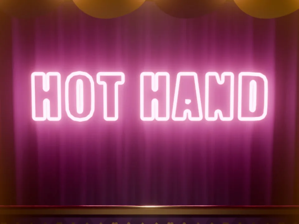 Hot Hand title screen: a pink neon sign over a carnival stage lined with bulbs